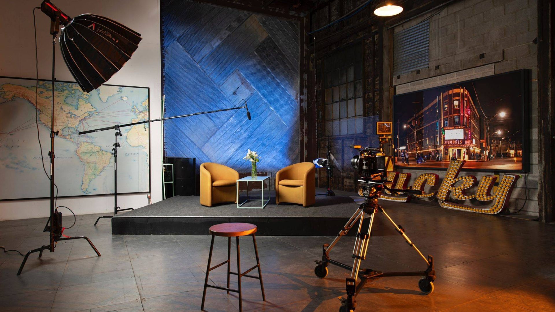 Interior of Motorista Studio A in Toronto — spacious vintage rental space with film set chairs, industrial props, and cinematic lighting